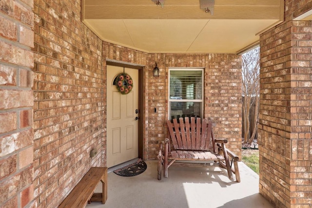 doorway to property with brick siding