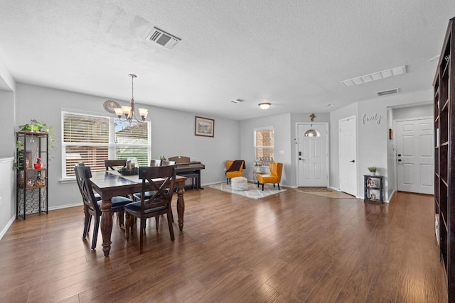 9017 Edmundsbury Dr, Austin, TX 78747 - dining room featuring a textured ceiling, a chandelier, and dark wood finished floors