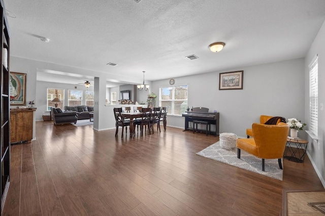 9017 Edmundsbury Dr, Austin, TX 78747 - dining room featuring a textured ceiling, dark wood-type flooring, a chandelier, and ceiling fan