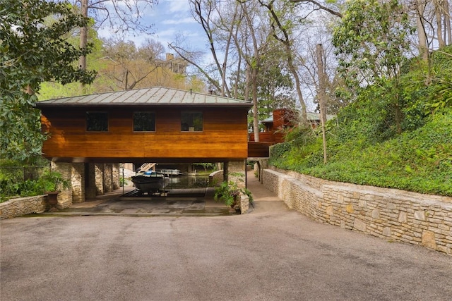 view of parking / parking lot with aphalt driveway and a carport