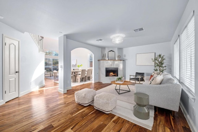 living room featuring visible vents, baseboards, wood finished floors, and a fireplace