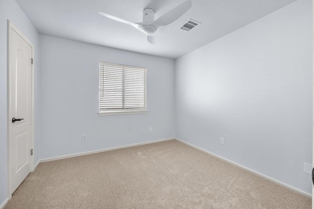 spare room with light carpet, visible vents, baseboards, and a ceiling fan