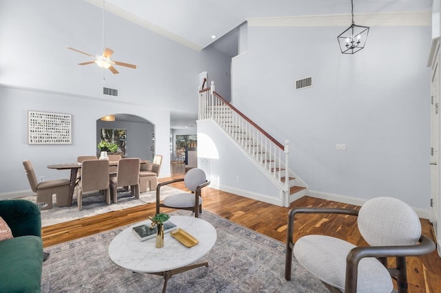 living area with wood finished floors, stairway, arched walkways, and visible vents