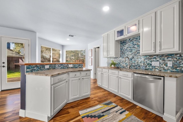 kitchen featuring a kitchen island, stainless steel dishwasher, wood finished floors, white cabinets, and decorative backsplash