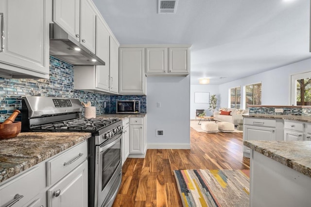 kitchen with visible vents, under cabinet range hood, wood finished floors, white cabinetry, and gas stove