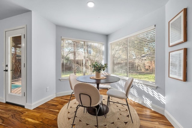 dining area featuring plenty of natural light, wood finished floors, and baseboards