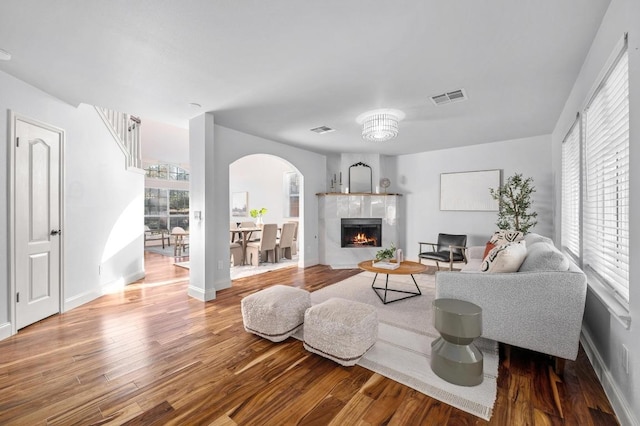 6303 Sam Maverick Pass, Austin, TX 78749 - living area with wood finished floors, arched walkways, a tile fireplace, and baseboards