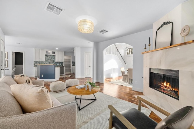 6303 Sam Maverick Pass, Austin, TX 78749 - living area with arched walkways, light wood-style flooring, baseboards, a fireplace, and recessed lighting