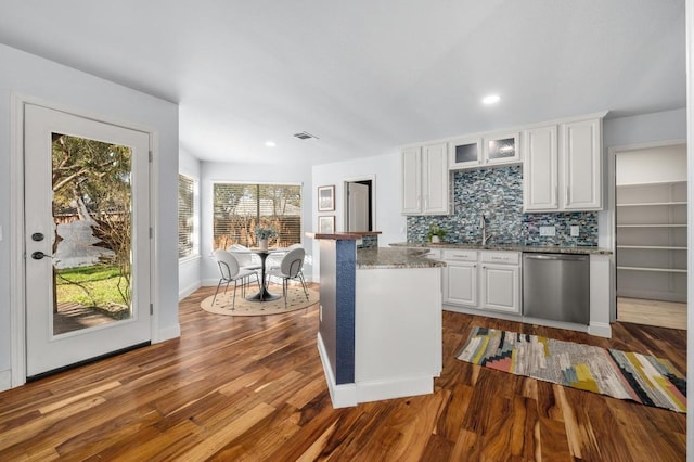 6303 Sam Maverick Pass, Austin, TX 78749 - kitchen with stainless steel dishwasher, white cabinets, dark wood-type flooring, glass insert cabinets, and backsplash