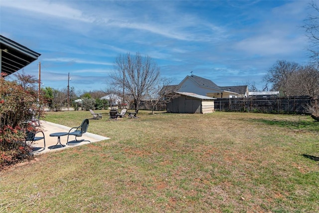 view of yard featuring a storage shed, an outdoor structure, an outdoor fire pit, and a patio area