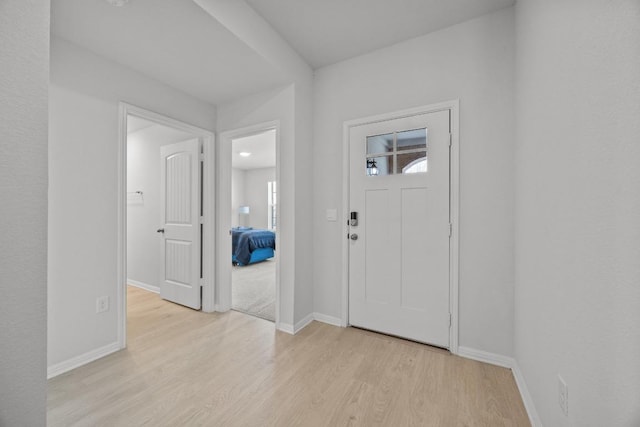 entrance foyer featuring baseboards and light wood finished floors