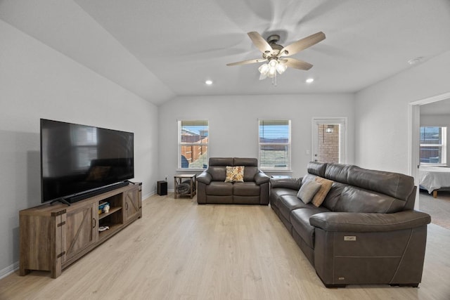 living area featuring baseboards, ceiling fan, vaulted ceiling, and light wood finished floors