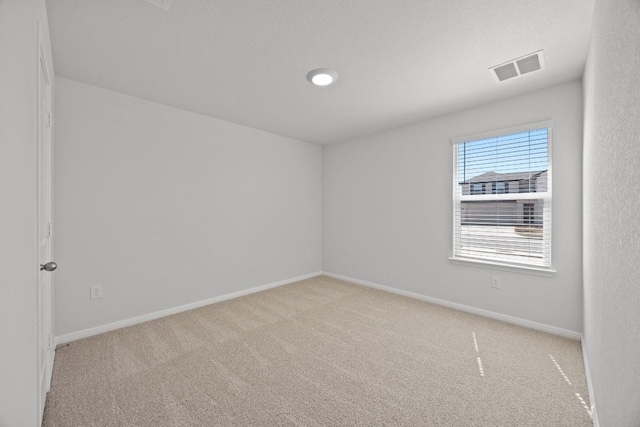 unfurnished room featuring visible vents, baseboards, and carpet