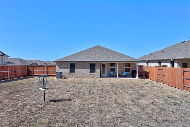 back of house with a patio, a fenced backyard, a shingled roof, brick siding, and central AC unit