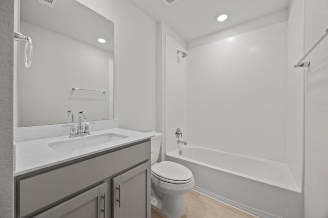 bathroom with visible vents, tub / shower combination, toilet, wood finished floors, and vanity