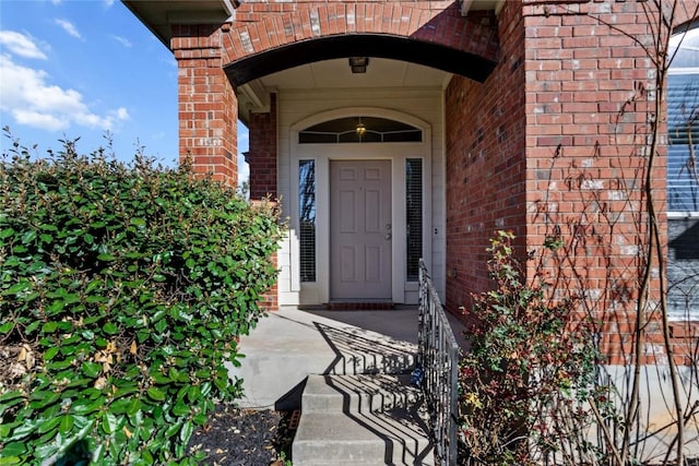 view of exterior entry with brick siding