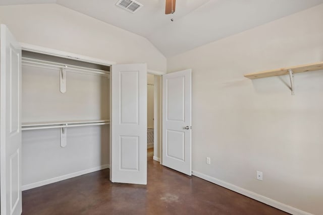 unfurnished bedroom featuring visible vents, finished concrete flooring, a closet, baseboards, and vaulted ceiling