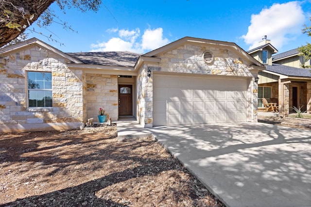 view of front of house featuring stone siding, driveway, a shingled roof, and a garage