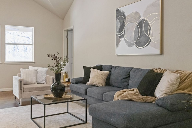 living room featuring baseboards, lofted ceiling, and wood finished floors