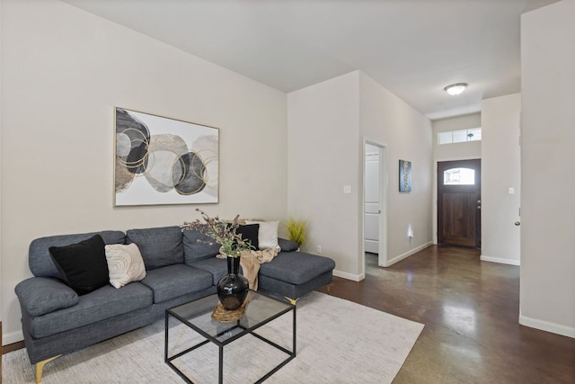 living area featuring concrete floors and baseboards