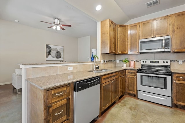 kitchen with visible vents, a peninsula, a sink, decorative backsplash, and appliances with stainless steel finishes