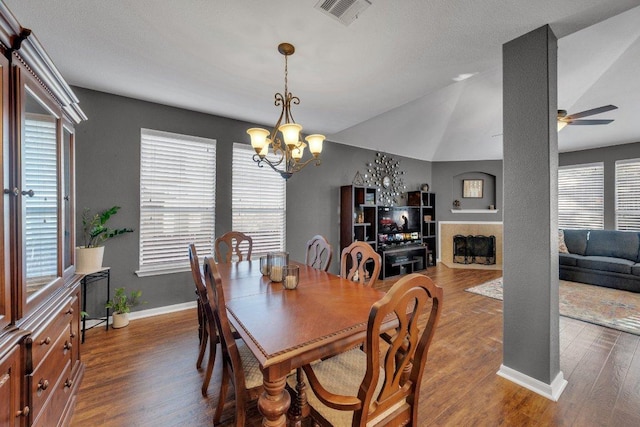 2157 Paradise Ridge Dr, Round Rock, TX 78665 - dining area with a chandelier, ceiling fan, wood finished floors, a fireplace, and vaulted ceiling