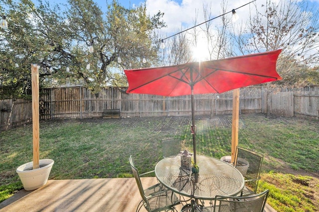 view of yard with outdoor dining area and a fenced backyard