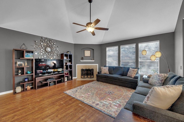 living area featuring high vaulted ceiling, wood finished floors, a fireplace, baseboards, and ceiling fan