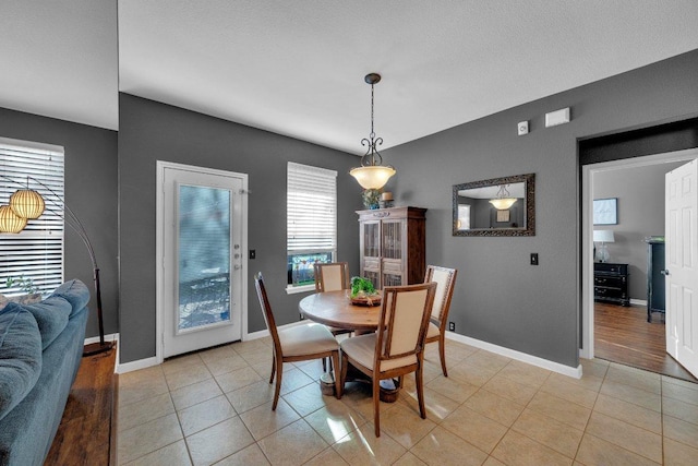 dining space featuring light tile patterned floors and baseboards