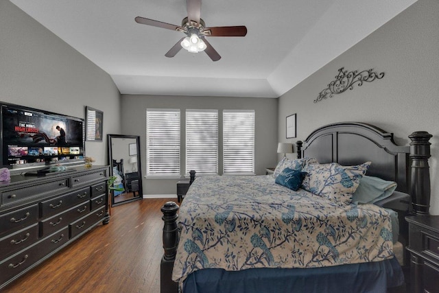 bedroom with baseboards, lofted ceiling, dark wood-type flooring, and a ceiling fan