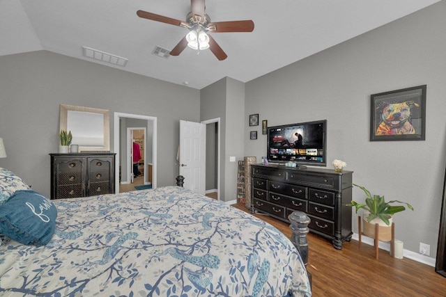 bedroom with visible vents, baseboards, lofted ceiling, and wood finished floors