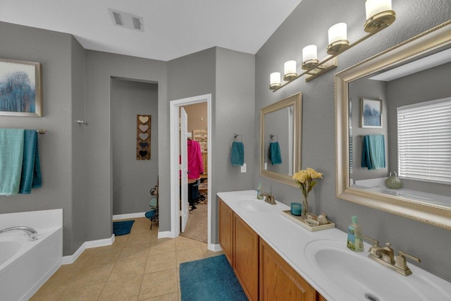 bathroom featuring tile patterned flooring, visible vents, a bath, and a sink