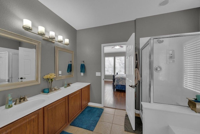 ensuite bathroom with tile patterned flooring, a stall shower, ensuite bath, and a sink