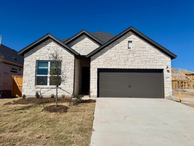 view of front of home with concrete driveway and an attached garage