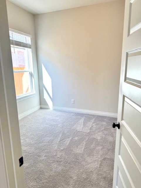 carpeted spare room featuring baseboards