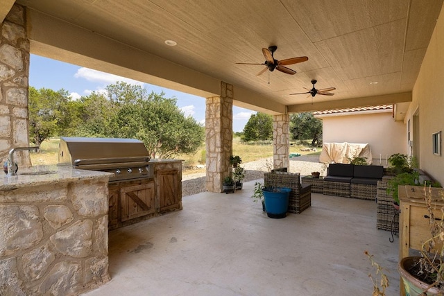 view of patio / terrace with a sink, an outdoor hangout area, an outdoor kitchen, and ceiling fan