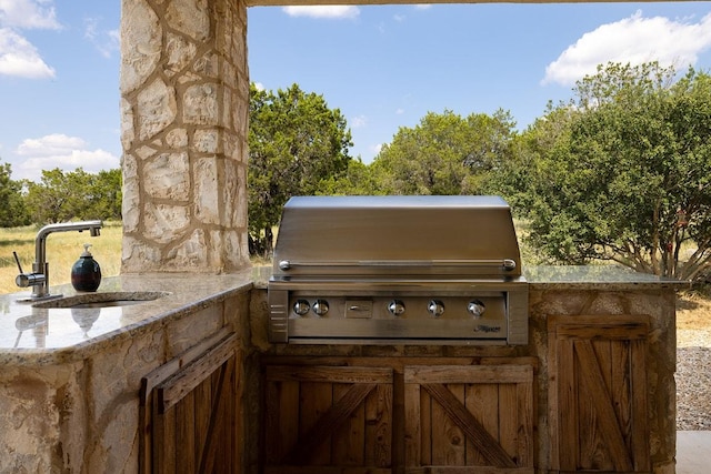 view of patio / terrace featuring a sink, exterior kitchen, and grilling area