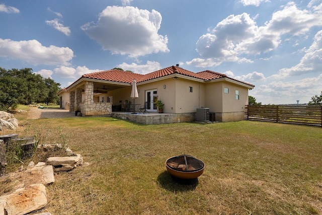 rear view of property with french doors, a fire pit, a yard, and fence