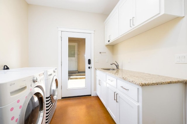 clothes washing area featuring washer and dryer, cabinet space, and a sink