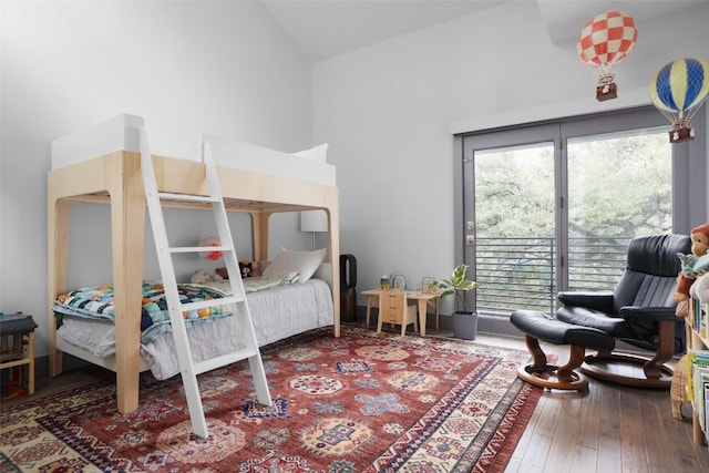 bedroom featuring multiple windows, high vaulted ceiling, and hardwood / wood-style floors