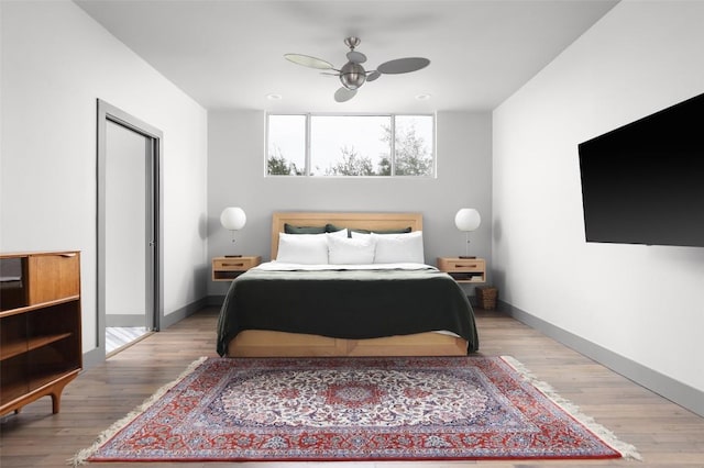 bedroom with wood finished floors and baseboards