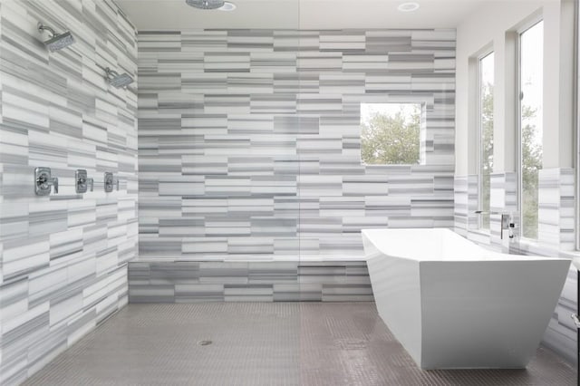 bathroom featuring a tile shower and a soaking tub