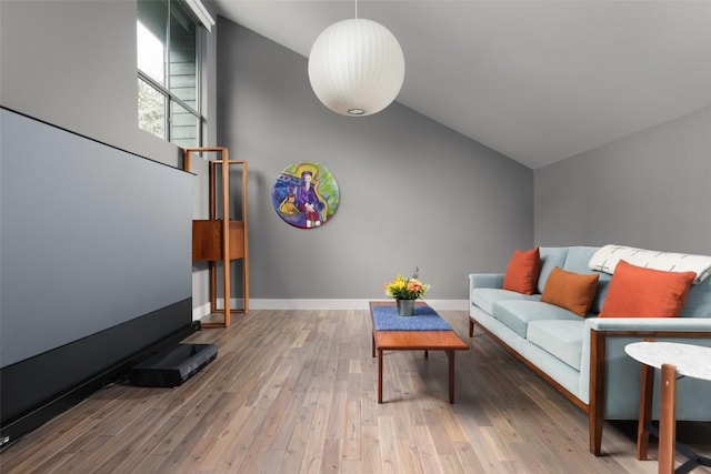 living room featuring baseboards, high vaulted ceiling, and wood finished floors