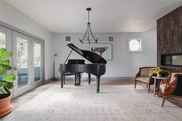 sitting room featuring visible vents, baseboards, an inviting chandelier, and wood finished floors