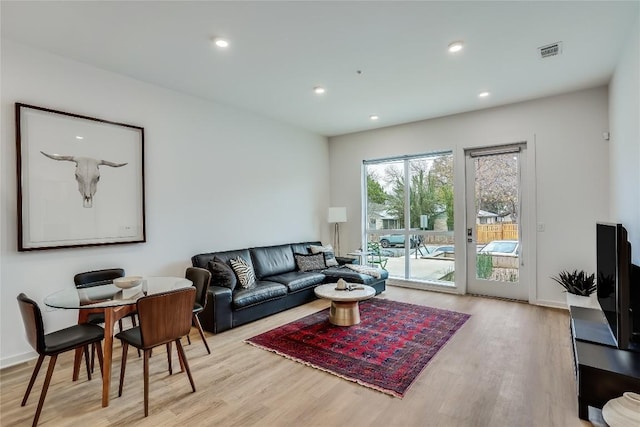 living room with visible vents, recessed lighting, and light wood-style floors