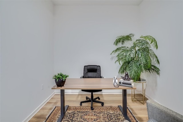 home office with baseboards and light wood finished floors