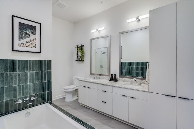 full bathroom featuring visible vents, toilet, a tub to relax in, and a sink