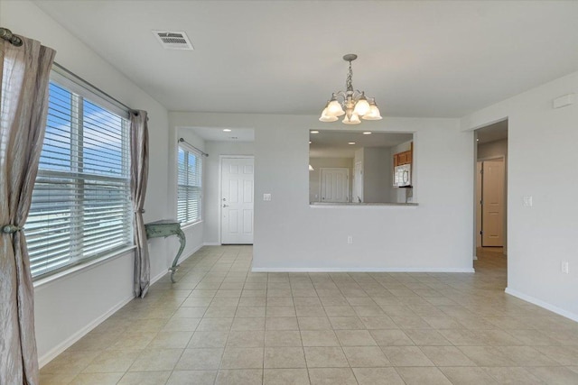 spare room featuring an inviting chandelier, light tile patterned floors, baseboards, and visible vents