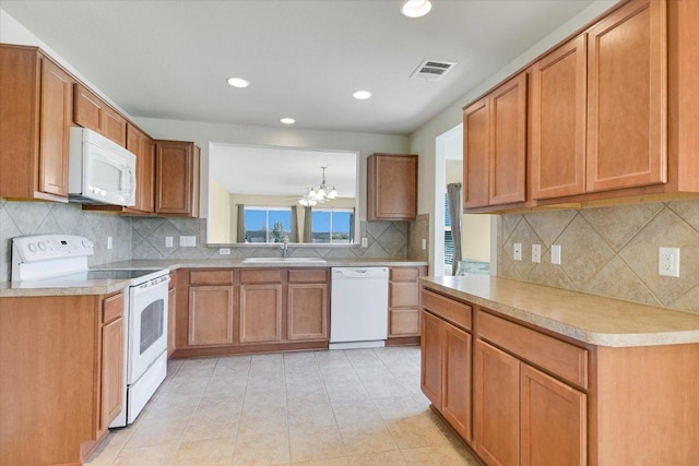 kitchen with visible vents, a notable chandelier, a sink, white appliances, and light countertops