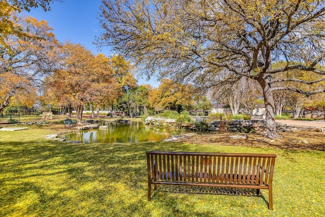 view of community with a lawn and a water view